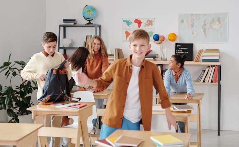 Cheerful students enjoying a break in a lively, diverse classroom setting.