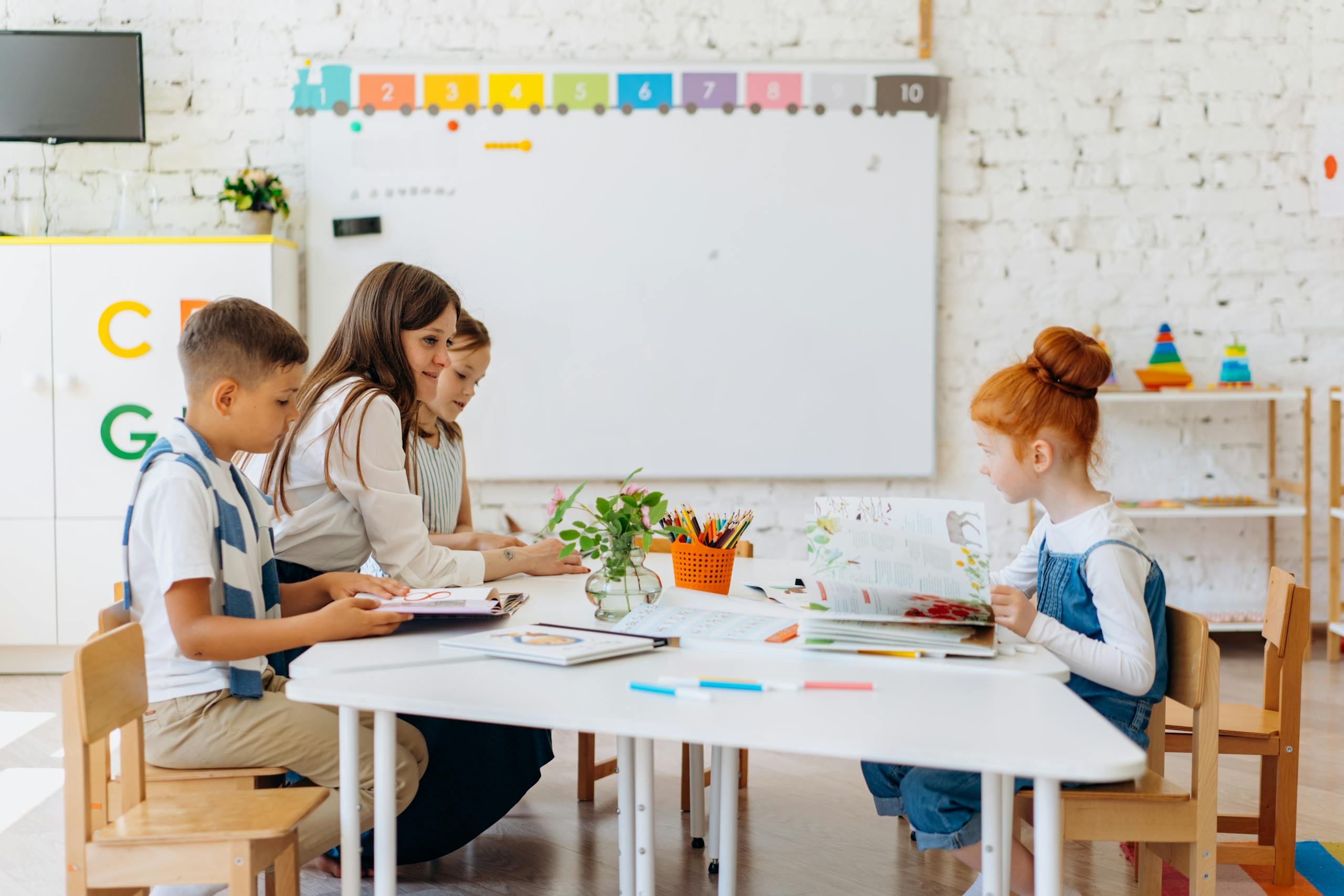 Students and teacher interacting in a bright, colorful classroom setting.