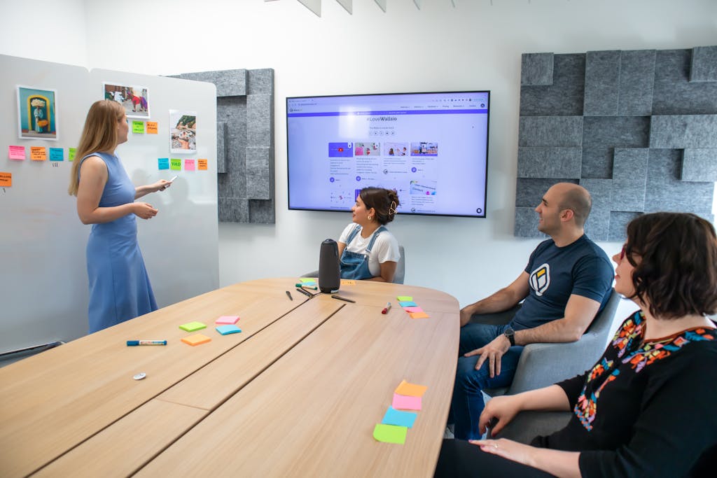 Business team engaged in presentation with sticky notes and digital screen in modern office.