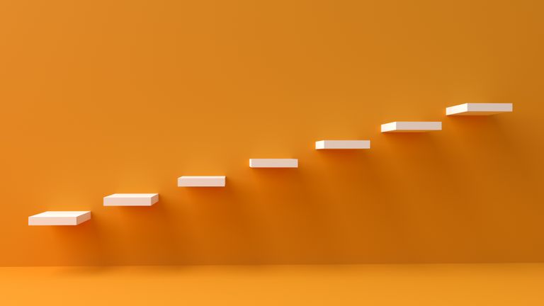 White floating steps on vibrant orange wall create a minimalist and conceptual design.